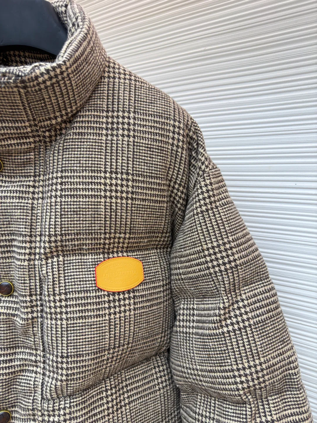 LOUIS VUITTON Tweed Plaid Tunic Stand Collar Long Sleeve Cotton Jacket ●Original version: Purchased and developed by 28699 ●Item No.: 1682302-C95 ●Fabric: Alpaca fabric ●Technology: Made by positioning cutting machine ●Color: Camel ●Version: Fitted version ●Weight: about 1725 grams ●Size: S-M-L-XL ●Description: This plaid down jacket is made of high-count wool-blend plaid fabric. It has been woven and dyed to create a rich brown-toned plaid texture. The fabric has been pre-shrunk and anti-pilling finished to give both texture and durability. The filling is made of gold-matched velvet material of 90% white goose down and 10% white goose feather, which is evenly distributed through the three-dimensional lattice filling process to eliminate the problem of velvet running; the stand-up collar version adopts a double-layer composite lining to lock the temperature, and the placket is customized with matte metal snaps and resin buttons of the same color, which fits the overall retro texture. The left chest is inlaid with a hand-polished cowhide logo plate, and the edges are oil-sealed. Each stitch adopts a 3cm/12-needle precision sewing standard, combined with the seamless taping process of invisible pockets, integrating functionality and craftsmanship details, fully displaying ingenuity and craftsmanship. The overall wiring is straight and delicate, the fabric is comfortable and soft, and the color is consistent without color difference. It can be matched with the same style to create a fashionable look and control various occasions. Customized accessories, complete with three standards, same style for men and women!
